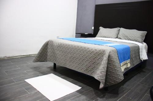 a bedroom with a large bed with a blue blanket at Loft Hermoso con Jacuzzi in Villahermosa