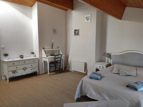 a bedroom with a bed and a desk and a chair at Les Chenets in Chenay