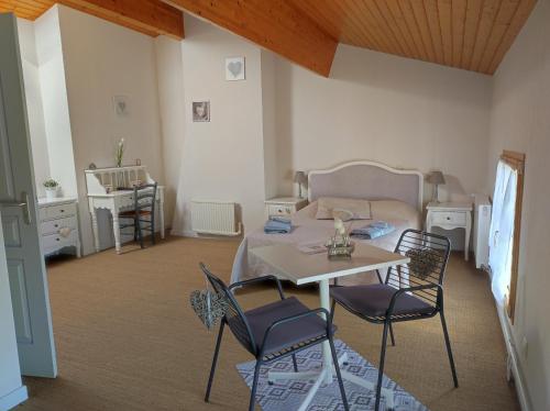 um quarto com uma mesa e cadeiras e uma cama em Les Chenets em Chenay