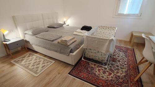 1 dormitorio con 1 cama, 1 silla y 1 alfombra en B&B Al Vecio Morer, en San Donà di Piave
