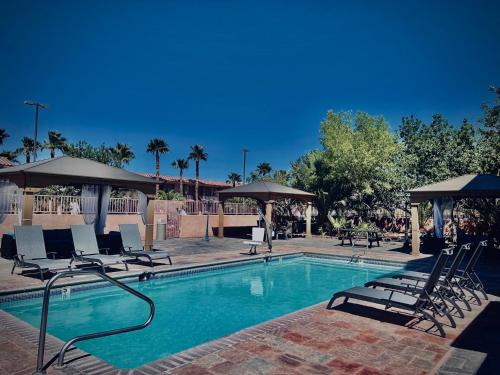 a swimming pool with chairs and umbrellas at Death Valley Inn & RV Park in Beatty