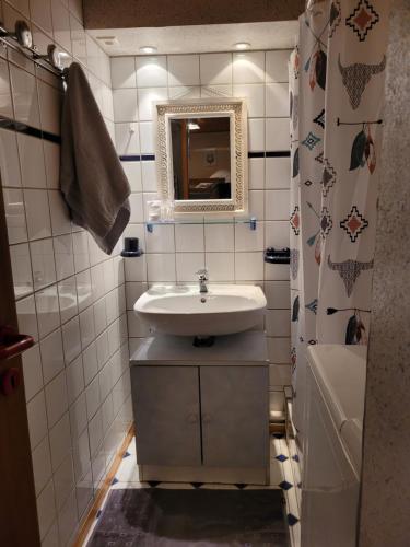 a bathroom with a sink and a mirror and a tub at Appartement chaleureux au cœur des Hautes Vosges in Ventron
