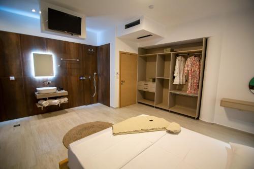 Pokój z łóżkiem i łazienką z umywalką w obiekcie Elea resort w Prewezie