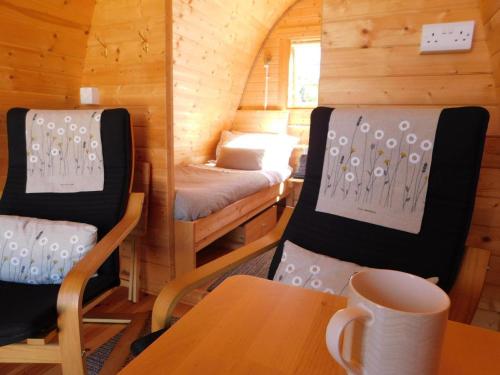 um pequeno quarto com uma cama, uma mesa e cadeiras em Cosy Pod-Cabin near beautiful landscape in Omagh em Omagh