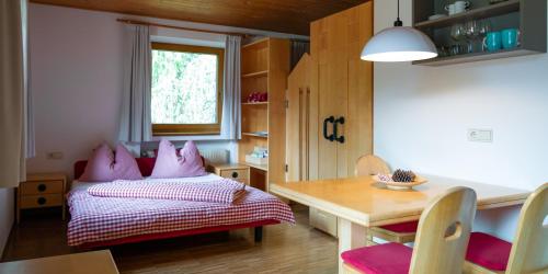 sypialnia z łóżkiem z różowymi poduszkami i stołem w obiekcie Residence Veider w mieście Rasun di Sotto