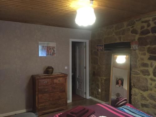 a bedroom with a bed and a stone wall at Casa do Castelo de Celorico in Celorico da Beira