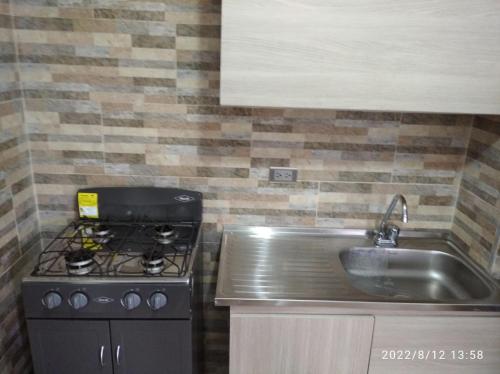 uma cozinha com um fogão e um lavatório em Apartamento Rodadero Edificio Rodadero Plaza 301A em Santa Marta