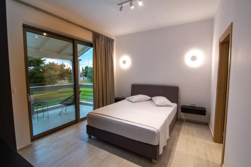 sypialnia z łóżkiem i dużym oknem w obiekcie Elea resort w Prewezie