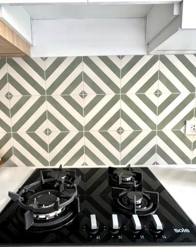a kitchen with a stove and a checkered wall at Vistamar Duplex in Lima