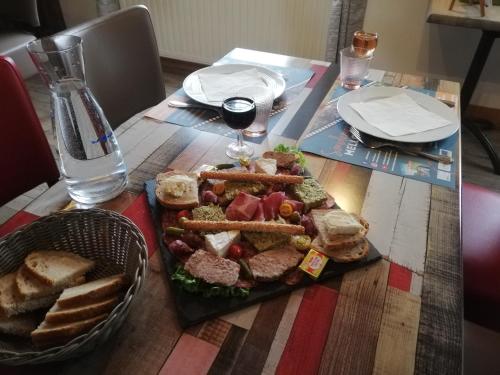 a table with a plate of food and a basket of bread at Les Chenets in Chenay