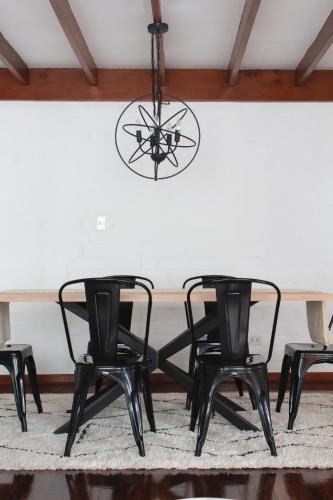 a dining room table with four chairs and a chandelier at Vistamar Duplex in Lima