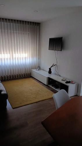 a living room with a flat screen tv and a couch at Apartamento T3 - férias in Barcelos