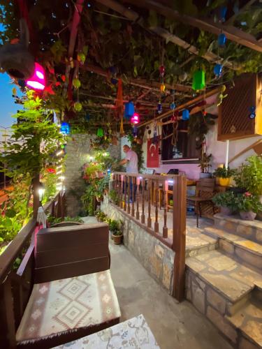 a patio with colorful lights and a man standing on a railing at Avcıoğlu Konak Otel in Safranbolu