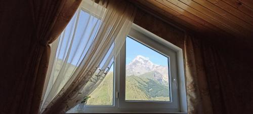 okno z widokiem na góry w obiekcie Guest House Tamta w mieście Stepancminda