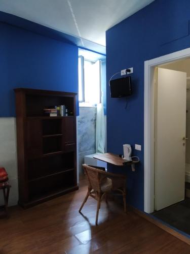 a room with a table and a blue wall at Affittacamere A Posada in La Spezia