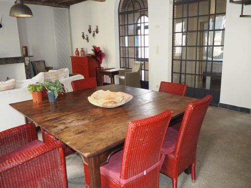 a dining room table with red chairs and a wooden table at Rubbensloft in Zele