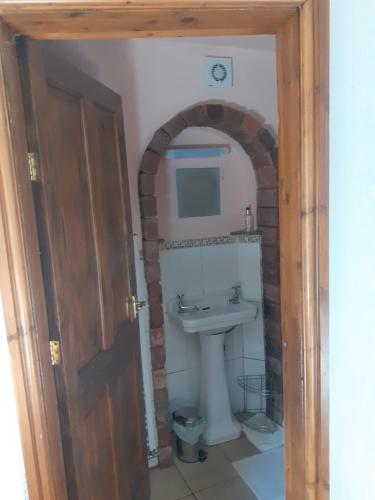 an entrance to a bathroom with a sink and a mirror at The Hayloft in Hartington