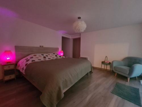 1 dormitorio con cama, silla y luces rosas en la parenthèse, en Entrevennes