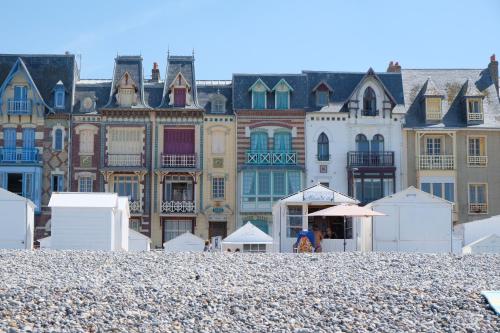 ル・トレポールにあるVilla Henriette - Confort et style 1900 à deux pas de la plageの小石のビーチの後ろにある建物の群れ