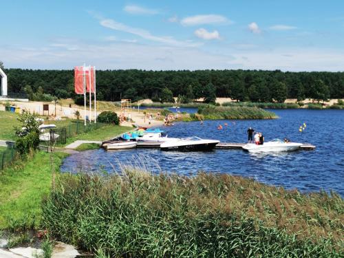 a group of boats docked at a dock on a lake at Leśny Apartament Nad Zalewem No. 2 in Kielce