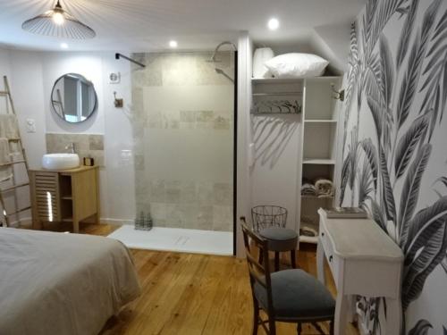 - une chambre avec une douche, un lit et un bureau dans l'établissement MAISON ATYPIQUE AVEC JARDIN AU PIED DU CLOS LUCE, à Amboise