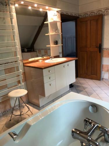 a bathroom with a bath tub and a sink at Détente à la compagne piscine chauffée billard et baby foot in Caugé