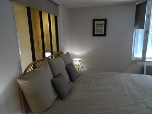 - une chambre avec un grand lit blanc et des oreillers dans l'établissement MAISON ATYPIQUE AVEC JARDIN AU PIED DU CLOS LUCE, à Amboise