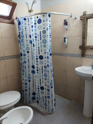 a shower curtain in a bathroom with a toilet and a sink at Terrazas de Aguas Dulces in Aguas Dulces