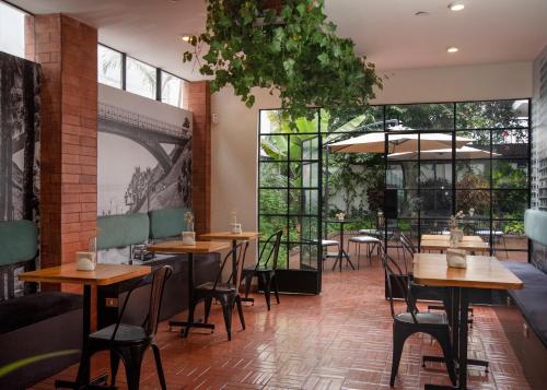 een restaurant met tafels en stoelen en grote ramen bij Lima 18 Boutique in Lima