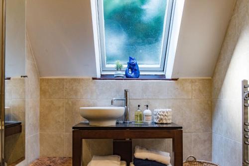 a bathroom with a sink and a window at The Coach House by Bloom Stays in Harrietsham