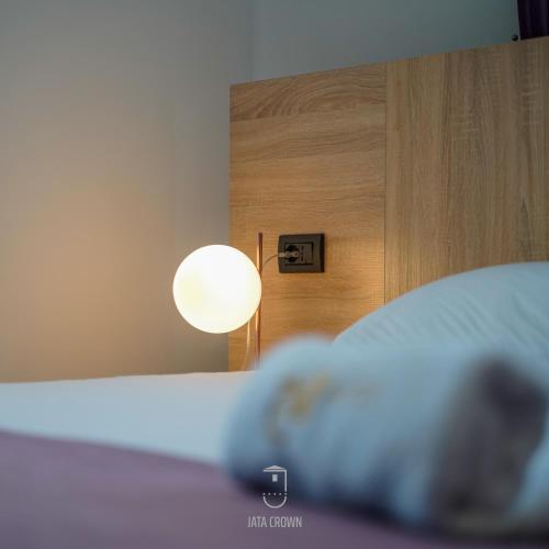 a bed with a lamp next to a wooden wall at Jata Hotel in Tirana