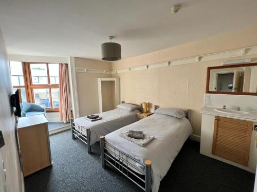 a hotel room with two beds and a sink at The Hoptimist in Stockton-on-Tees