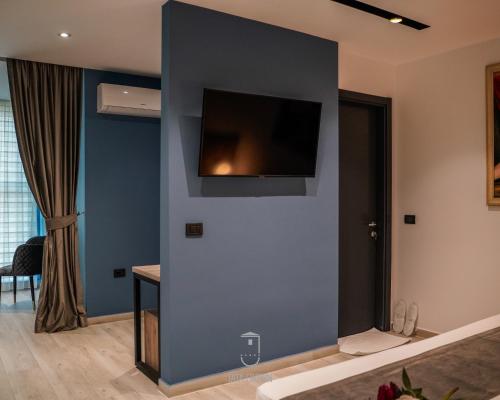 a room with a blue wall with a tv on it at Jata Hotel in Tirana