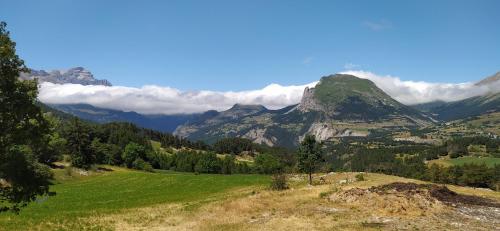 a grassy hill with mountains in the background at Superdevoluy appart 7ème étage sud Aurouze in Superdevoluy
