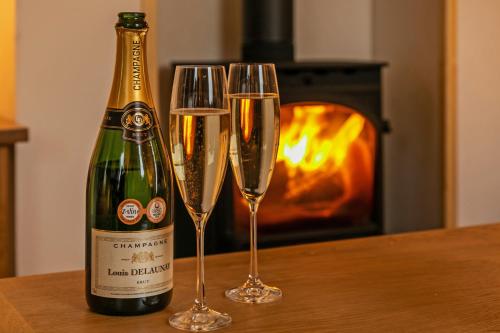 a bottle of champagne and two glasses on a table at The Nestle House in Winchester