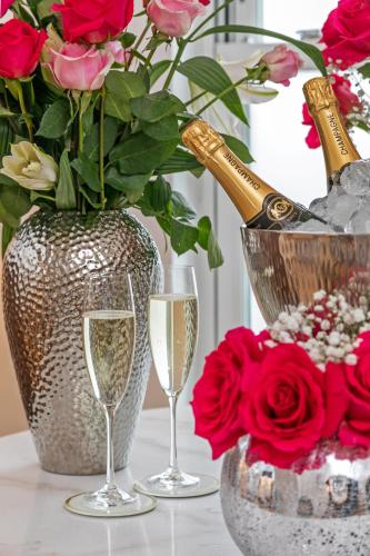 two glasses of champagne and a vase with flowers at The Nestle House in Winchester