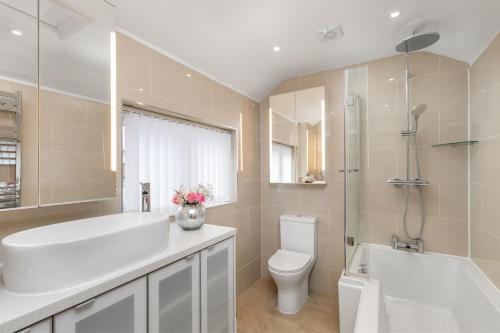 ein Badezimmer mit einer weißen Badewanne, einem WC und einem Waschbecken in der Unterkunft The Nestle House in Winchester