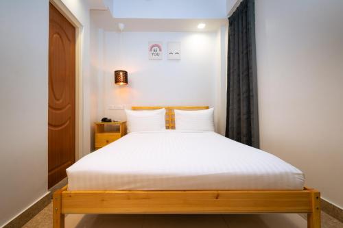 a bedroom with a bed with white sheets at Beach Breeze and Spa in Hulhumale