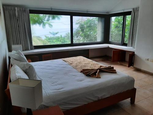 Villas Mayaluum Cozumel في كوزوميل: غرفة نوم مع سرير مع قوس عليه