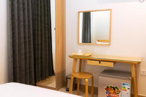 a bedroom with a table and a mirror at Beach Breeze and Spa in Hulhumale
