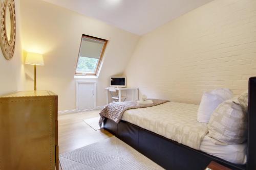 1 dormitorio con cama, ventana y escritorio en Talbot Woods Villa en Bournemouth