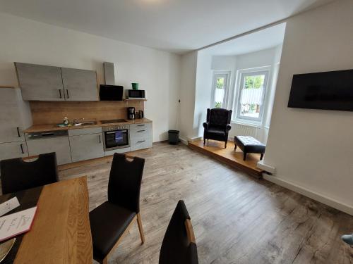 a living room with a table and chairs and a kitchen at Ferienwohnungen Appartementhaus Hohe Tauern in Obervellach