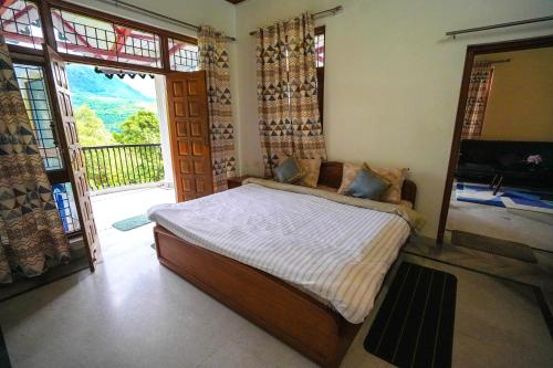 a bedroom with a bed and a large window at Chirping Hills Resort,Bhimtal in Bhīm Tāl