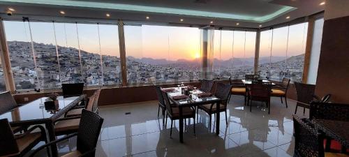 a restaurant with tables and chairs and a view of a city at Petra Elite Hotel in Wadi Musa