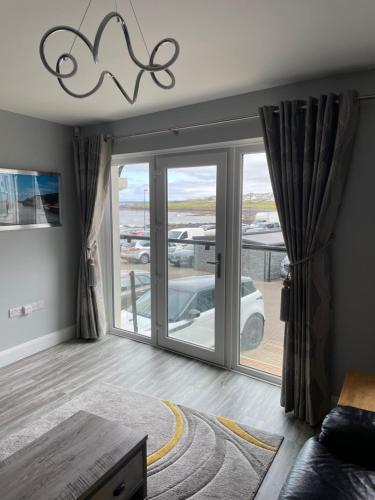 a living room with a sliding glass door at Atlantic Port Retreat in Portstewart