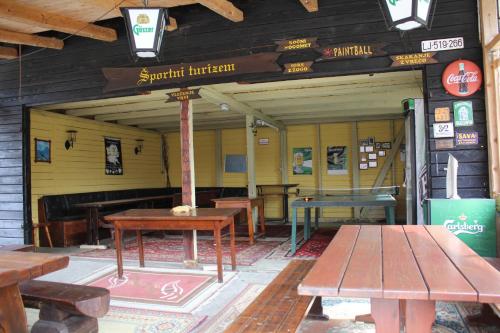 a restaurant with wooden tables and benches in a building at Guest House Kraljev Hrib in Kamniška Bistrica