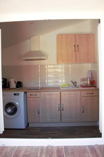 une cuisine avec un évier et une machine à laver dans l'établissement Maisonnette OCELIA 2 personnes Port de la Madrague, à Marseille