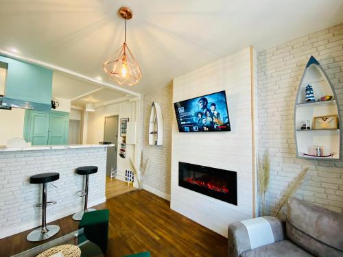a living room with a white brick wall with a fireplace at Appartement Vert du Palais - Relaxation Centrale in Le Palais