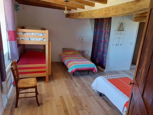 een slaapkamer met 2 stapelbedden en een stoel bij Gîte 11 personnes avec extérieur in Saint-Maurice-de-Rotherens