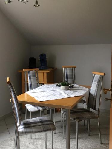 a dining room table with four chairs around it at Ferienwohnung Euler in Odernheim